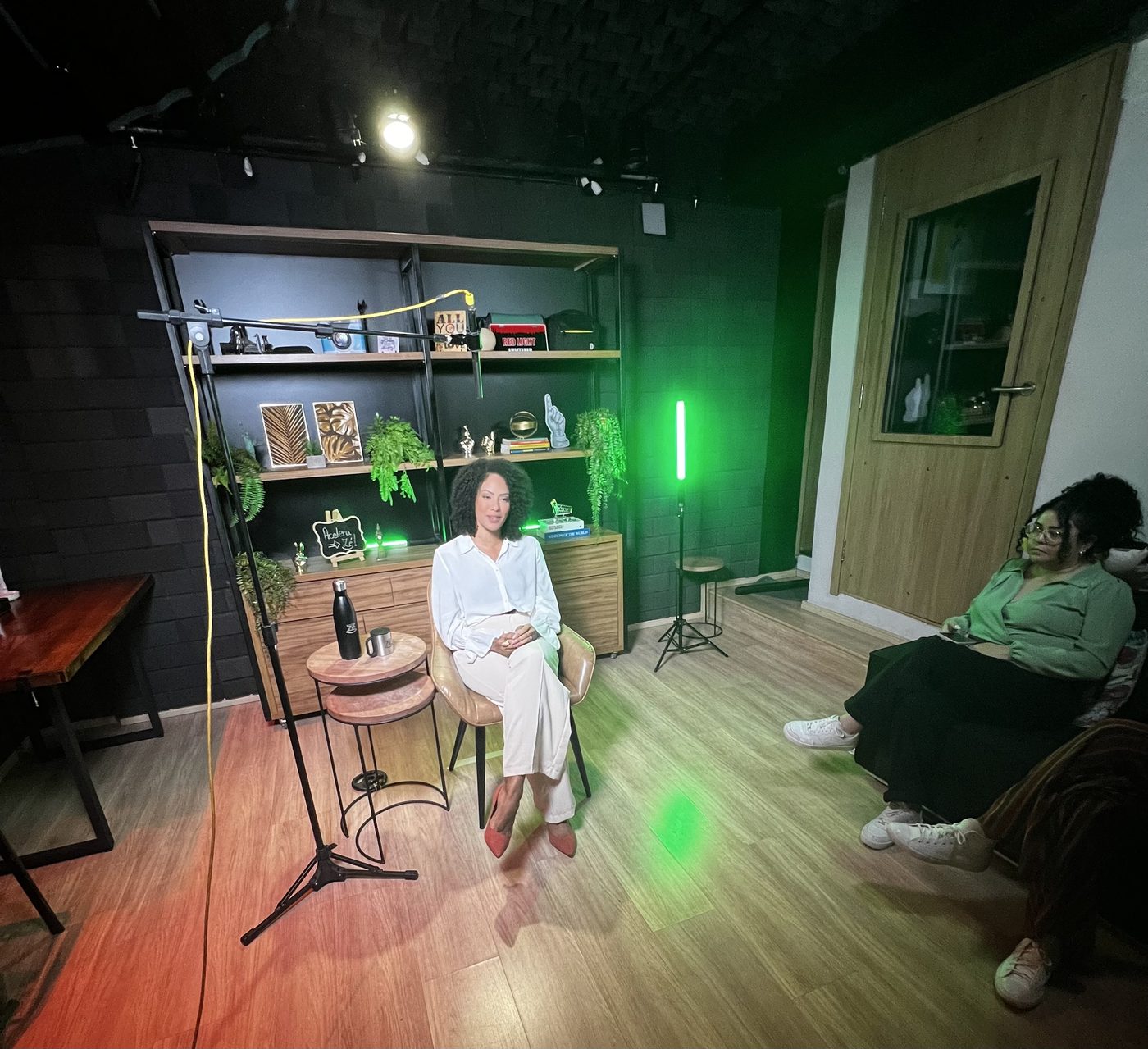 Sala cenográfica com iluminação verde e móveis personalizados